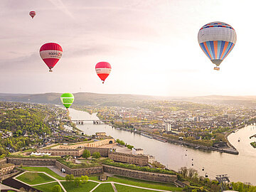 Fotowettbewerb #WelterbeVerbindet 2026 Platz 1 Blick auf Koblenz über die Festung Ehrenbreitstein mit aufsteigenden Heißluftballons