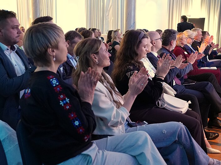 Die Personen im Publikum klatschen