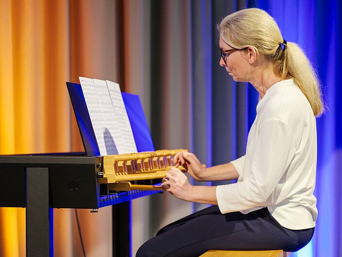 Carillonspielerin an einem &Uuml;bungscarillon spielt Glockenmusik