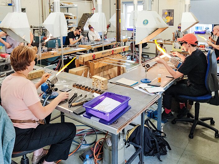 Teilnehmende der Internationalen Sommerakademie Bild-Werk Frauenau in der Lampenglaswerkstatt