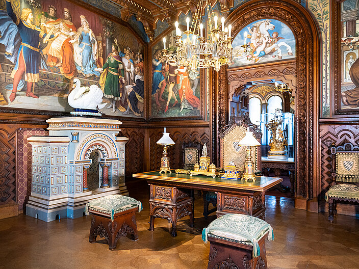 Prunkvoll gestaltetes Arbeitszimmer mit prächtigen Wandgemälden und Goldverzierungen im Schloss Neuschwanstein