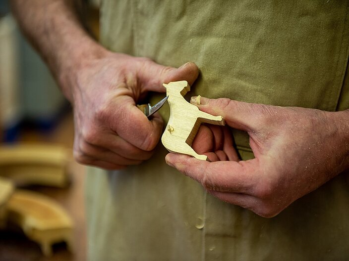 Holzfigur in Form eines Pferdes wird händisch geschnitzt
