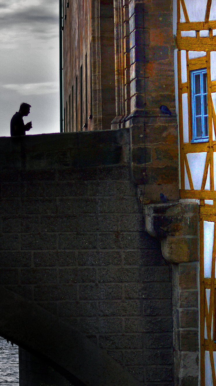 Ansicht einer Fachwerkhausfassade mit angrenzender Brücke in der Altstadt von Bamberg