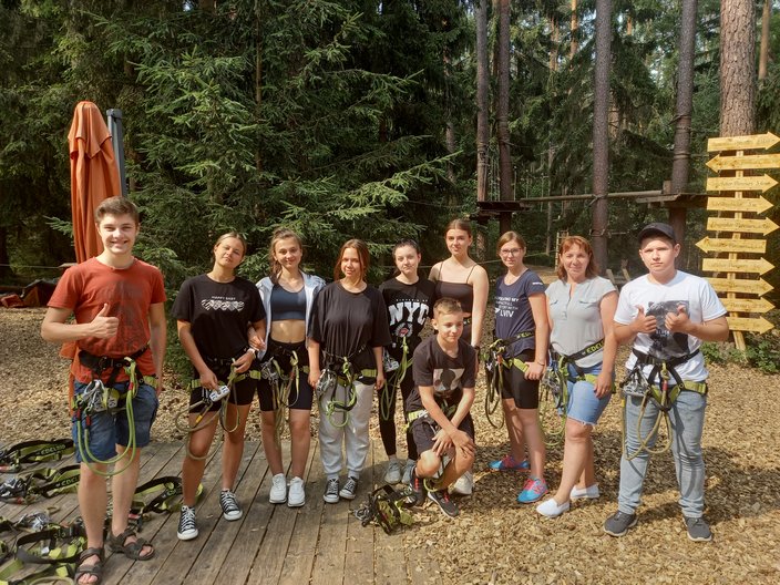 Recreation-Projekt 2023 in Nürnberg - Kletterausflug Die Gruppe steht mit Klettergurten angezogen im Wald.
