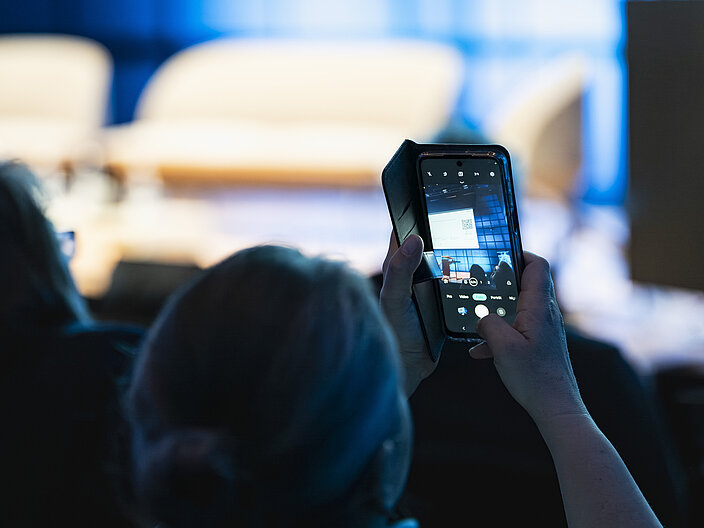 Handyfoto Person fotografiert die Bühne mit dem Smartphone