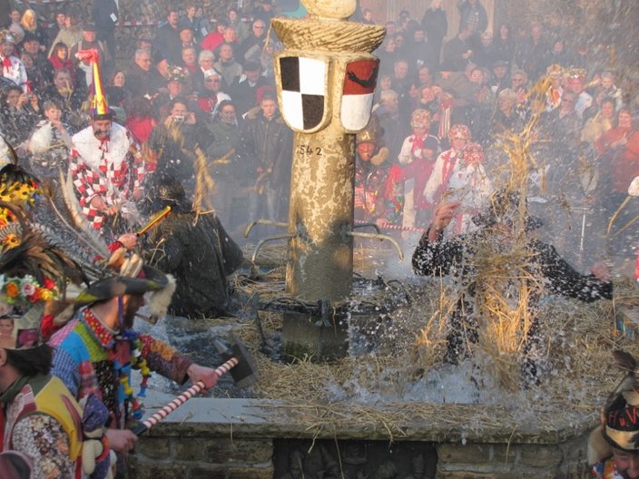 Kostümierte Personen baden in einem Brunnen