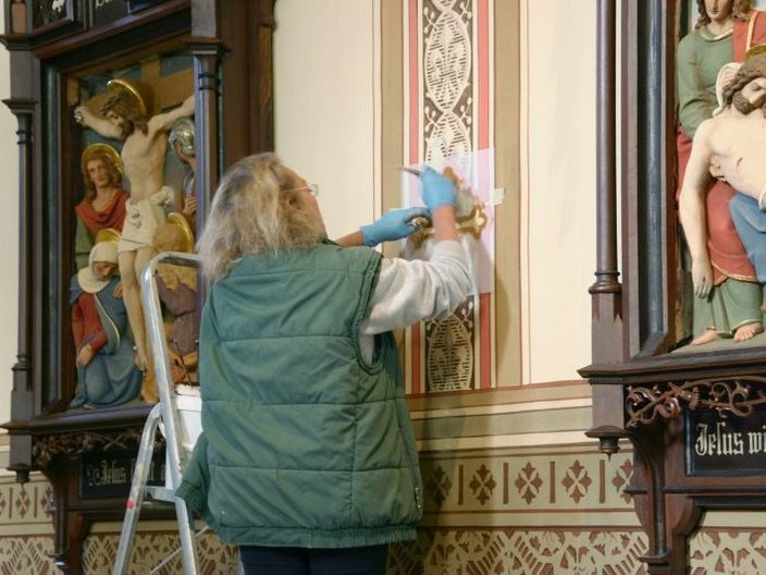 Restauration eines Schmuckelements in einer Kirche