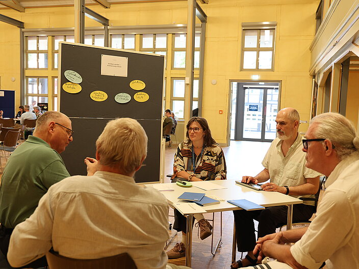 Arbeitsgruppe "Sichtbar werden" im Gespr&auml;ch. F&uuml;nf Personen sitzen an einem Tisch