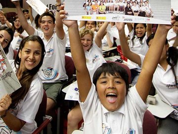 Das Bild zeigt fröhliche Kinder und Jugendliche mit nach oben gestreckten Armen. Im World Heritage Education Programme der UNESCO setzen sich junge Menshen für den Schutz unseres gemeinsamen Kultur- und Naturerbes ein