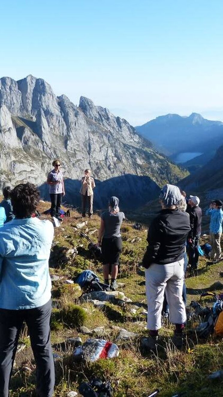 Menschen stehen in den Bergen und jodeln gemeinsam
