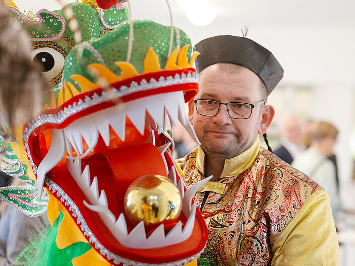 Tr&auml;ger des Chinesenfaschings mit einer Drachenkopffigur in der Hand.