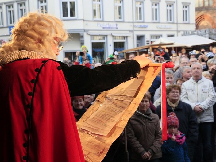 Mann mit rotem Mantel, Halskrause und Perücke auf öffentlichem Platz