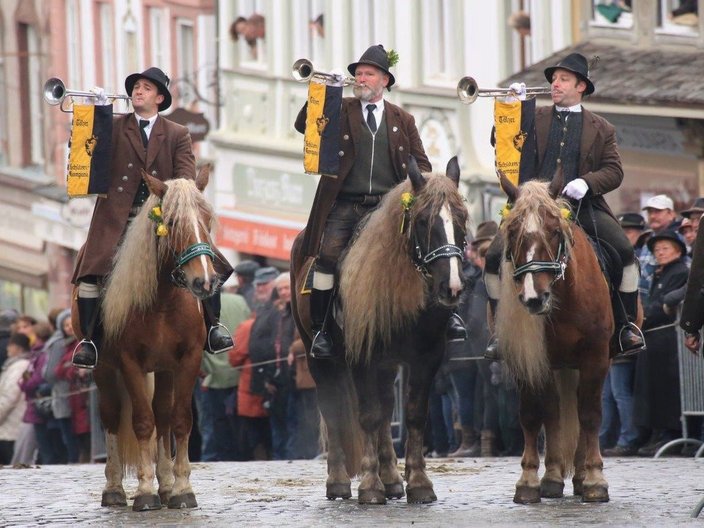Drei berittene Trompeter in Tracht