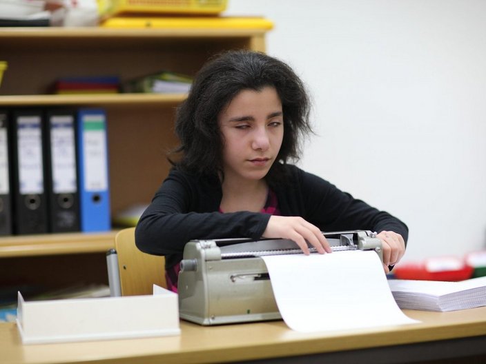 Mädchen schreibt in Brailleschrift