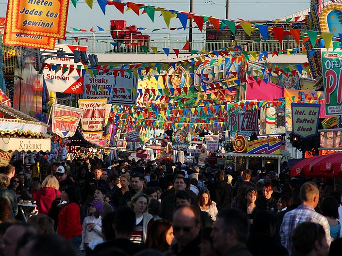 Buntes Treiben auf dem Fr&uuml;hlings-Volksfest in K&ouml;ln: Menschen in ihrer Vielfalt besuchen den Bummel &uuml;ber den Festplatz