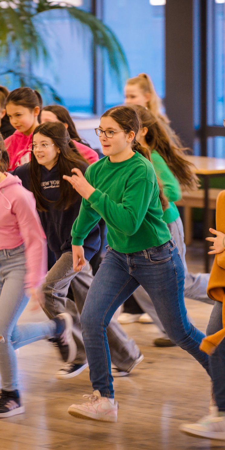 Schülerinnen und Schüler laufen durch einen Schulflur