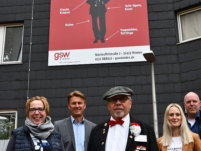 Veranstaltende stehen vor einem großen Werbeplakat für den Mindener Buttjersprachkurs.
