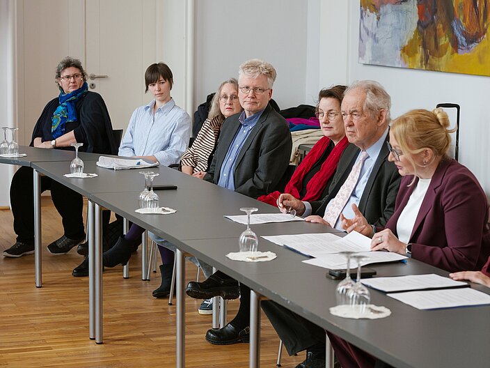 Urkundenverleihung_25_Pressekonferenz Langer Tisch mit Personen auf Pressekonferenz.