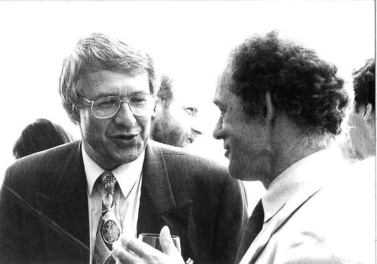 Schwarz-wei&szlig; Foto aus den 90er Jahren von zwei M&auml;nnern, die sich unterhalten 