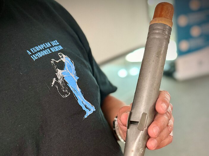 Person hält eine Jazzflöte in beiden Händen. Nahaufnahme der Jazzflöte.
