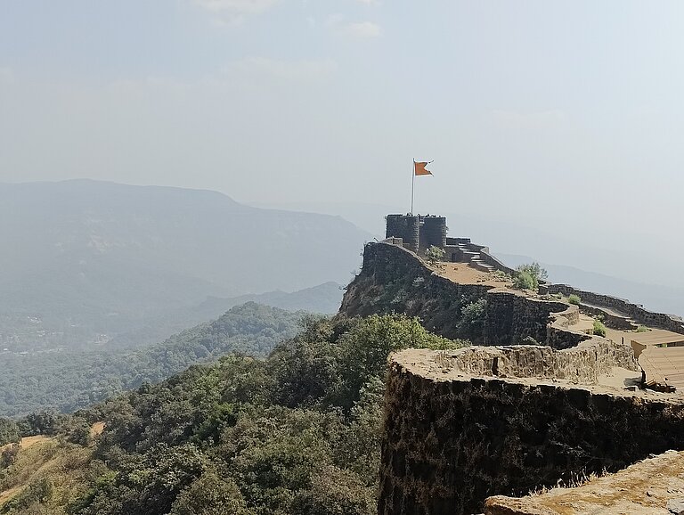 Blick auf eine Bergfestung mit einer Flagee