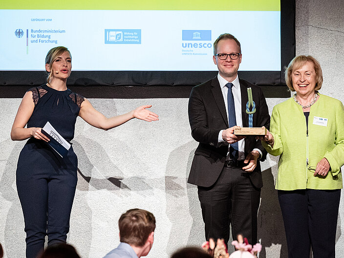 Auf diesem Foto sind folgende Personen zu sehen: Moderatorin Janine Mehner Herr Parl. Staatssekret&auml;r Dr. Jens Brandenburg, Bundesministerium f&uuml;r Bildung und Forschung beim BNE-Preis 2022