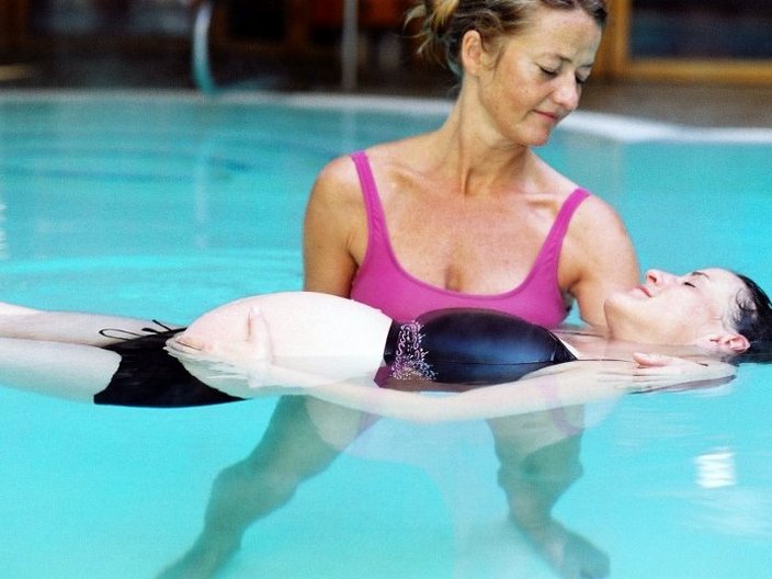 Hebamme mit Schwangere im Schwimmbad