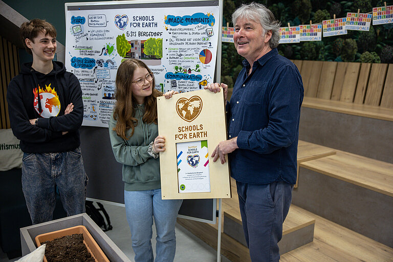 Auf diesem Foto ist ein Greenpeace Mitarbeitender mit Sch&uuml;ler:innen beim Schools for Erth Projekt zu sehen