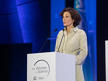 Audrey Azoulay an einem Rednerpult zu 'For Women in Science' Generaldirektorin der UNESCO, Audrey Azoulay, spricht an einem Rednerpult. Auf dem Rednerpult steht "For Women in Science"