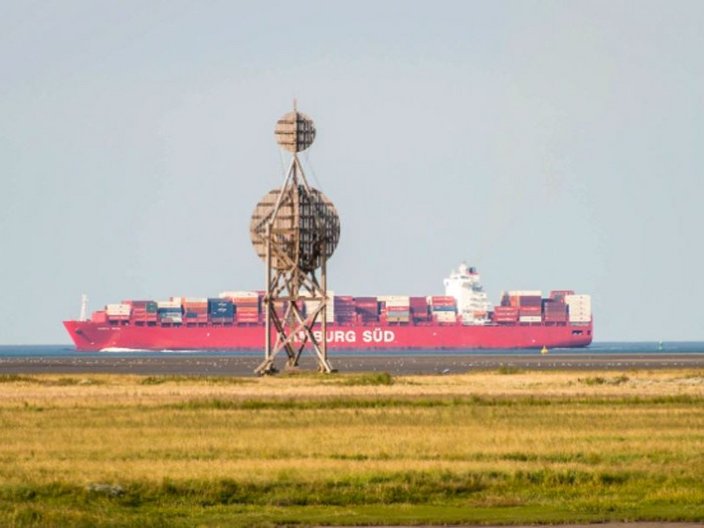 Containerschiff mit Insel im Vordergrund