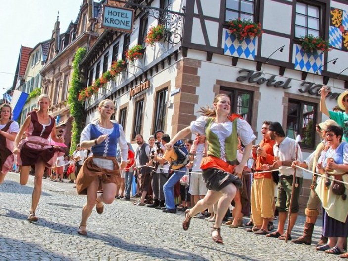 Frauen in Tracht rennen durch die Straße