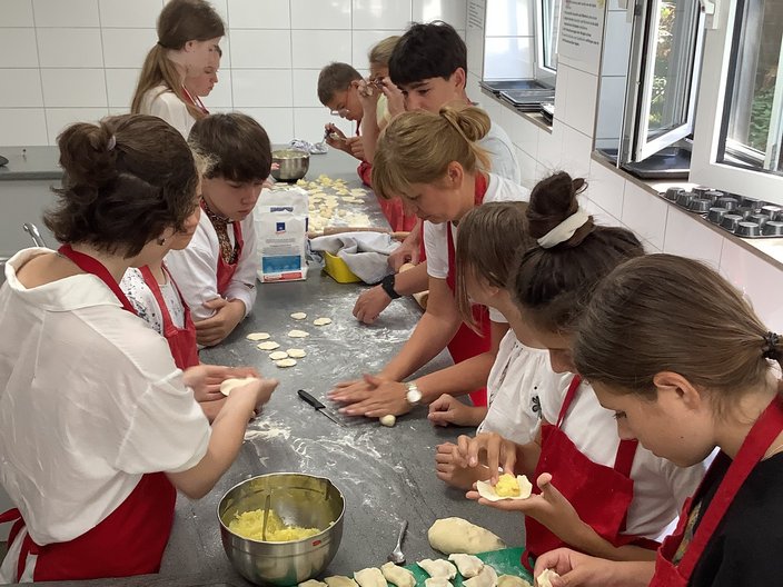 Recreation-Projekt 2023 in Rheine - Ukrainisch Kochen Schüler und Schülerinnen sind in der Schulküche und stellen gemeinsam Vereniki, ein ukrainisches Gericht, her.