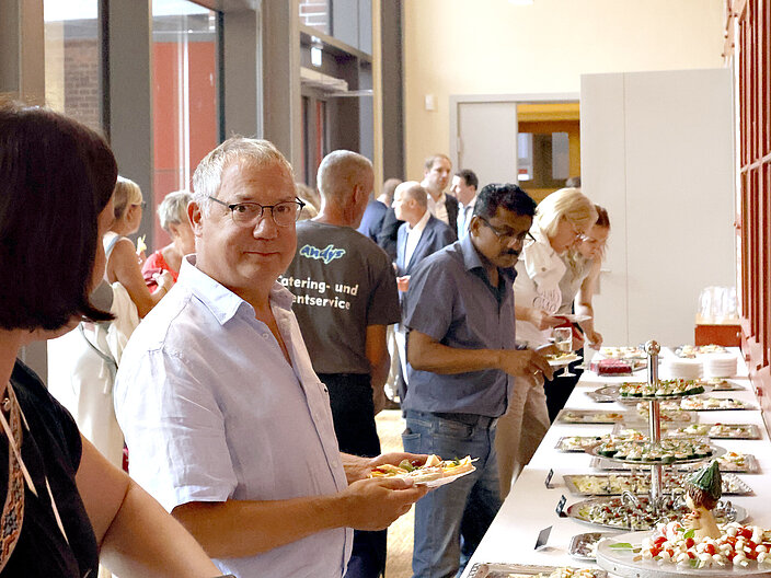 Menschen vor dem aufgebauten Catering im Vestib&uuml;l des Wichernsaals
