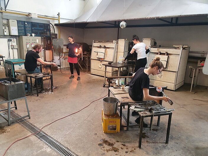 Glasmacher:innen arbeiten im Heißglasstudio des Bild-Werk Frauenau