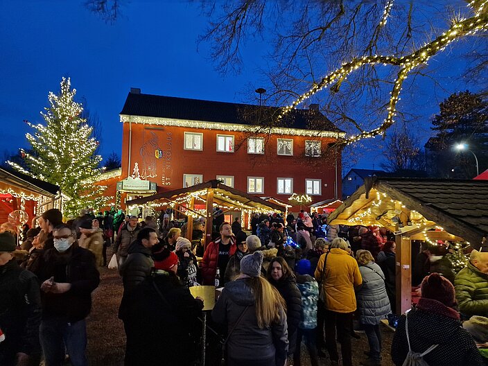 Vor dem Nikolauspostamt kommen Menschen zusammen um Nikolaus zu feiern