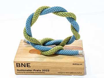 Auf diesem Foto wird die BNE-Preistrophäe der Kategorie Bildungslandschaften aus dem Jahr 2023 gezeigt. 