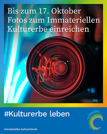 Abgebildet ist eine Kamera in Nahaufnahme, von der die Linse im Vordergrund steht. Eingerahmt ist das bild in einen bunten Rahmen. Unter dem Bild steht #Kulturerbe leben. immaterielles-kulturerbe.de