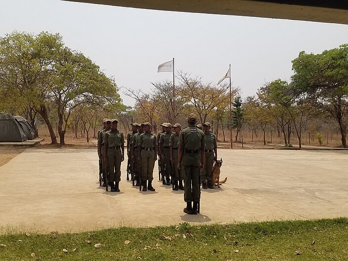 Frauen in Uniform stehen auf einem Platz, ähnlich wie beim Militär. Vor ihnen die Ausbildungsleitung. 