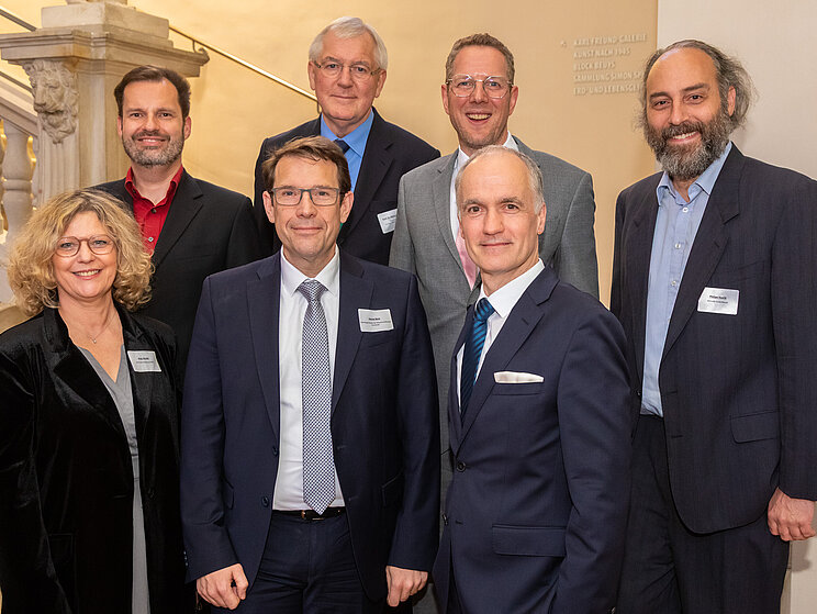 Eröffnung der Jahrestagung der Welterbestätten 2025 in Darmstadt - Gruppenfoto Ein Gruppenfoto von sechs Männern und einer Frau in zwei Reihen auf einer Treppe.