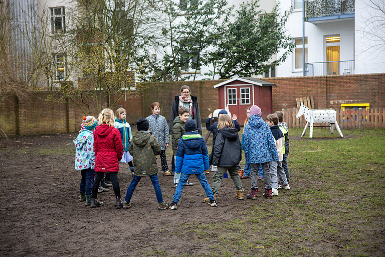 auf diesem Foto sind spielende Kinder mit einer Betreuerin zu sehen 