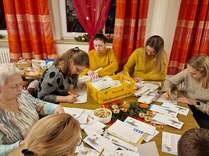 Helfende im Nikolauspostamt beantworten gemeinsam Kinderbriefe