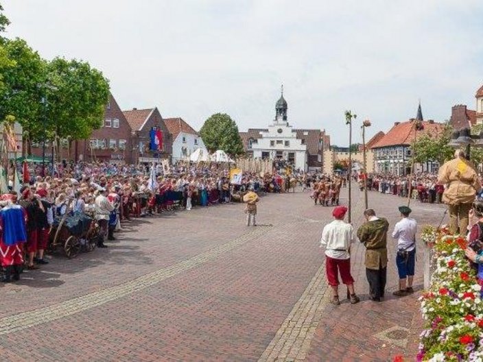 Festumzug auf einem historischen Platz mit Publikum