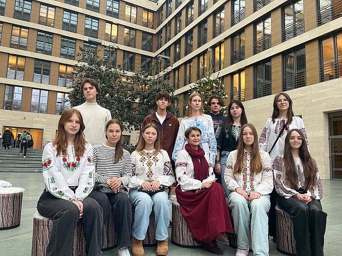 Die 15-köpfige Gruppe sitzt in traditioneller ukrainischer Kleidung in der Vorhalle des Auswärtigen Amtes in Berlin.