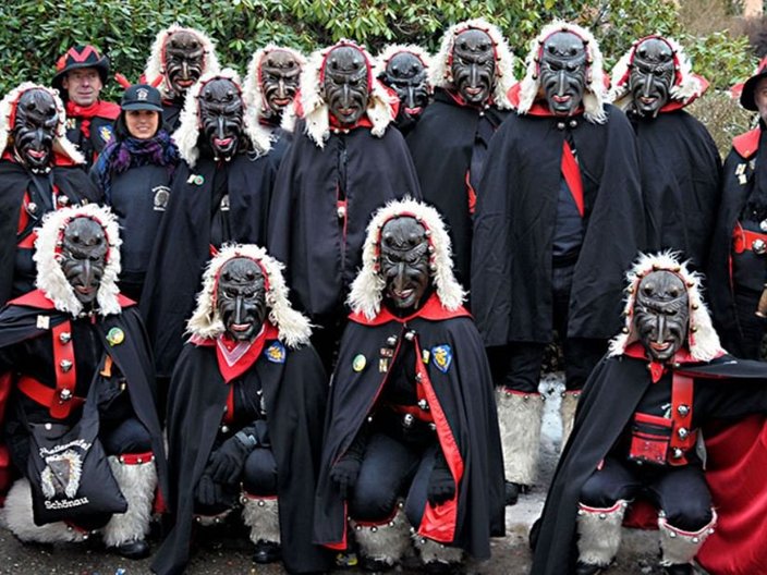 Gruppenfoto einer Trachtengruppe mit Holzmasken