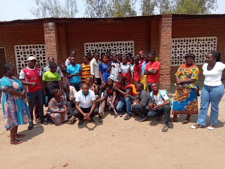 Teilnehmende des MAB-Projektes Eine Gruppe Teilnehmendes des MAB-Projektes in den Bioshärenreservaten Lake Chilwa Wetland und Mount Mulanje steht vor einem Haus. Die circa 20 Personen schauen lächelnd in die Kamera.