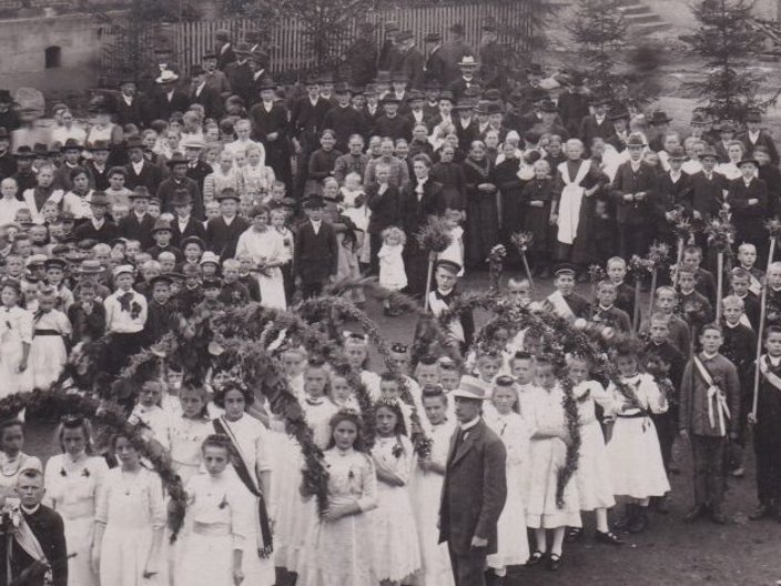 Schwarzweißfoto eines Festumzugs mit Kindern
