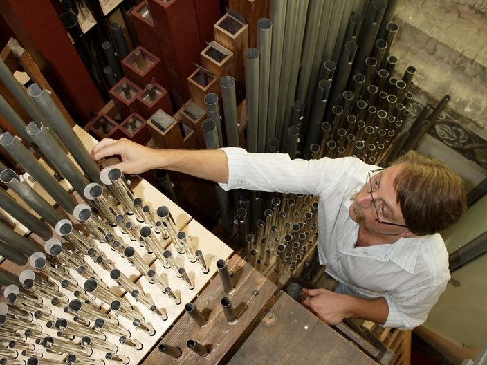 Ein Orgelbauer im Pfeifenraum seiner Orgel