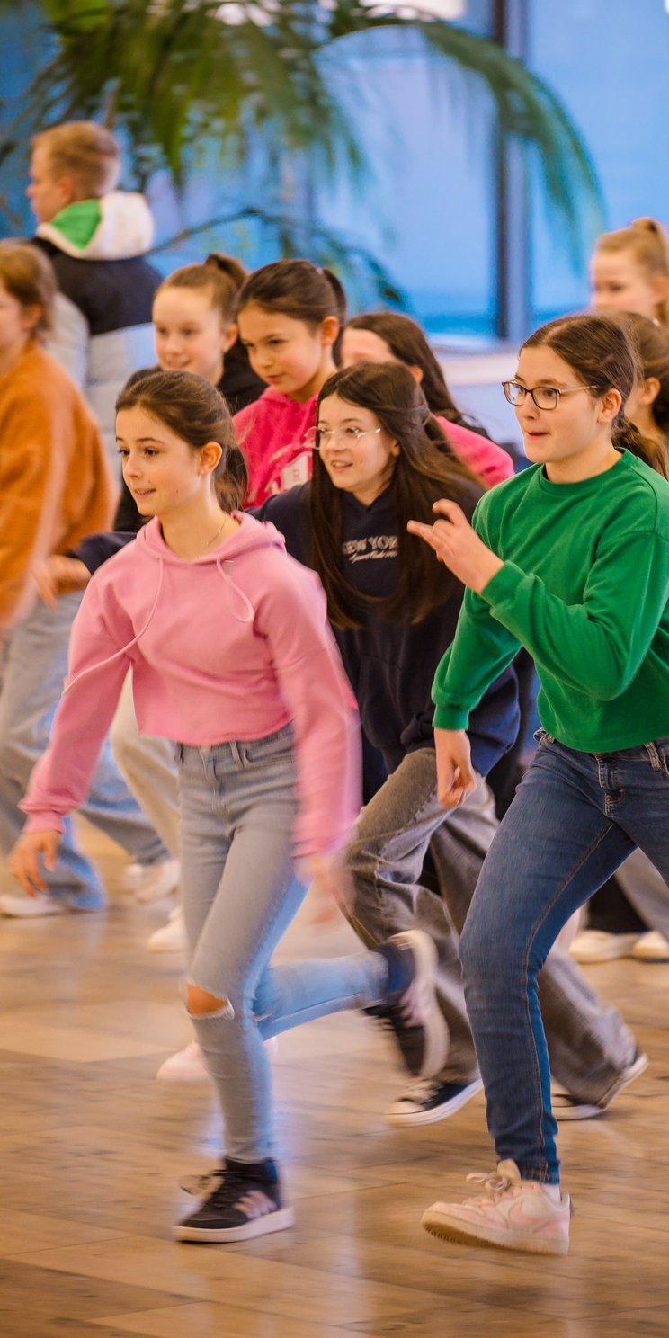 Schülerinnen und Schüler laufen durch einen Schulflur