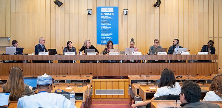 Public consultation process on the Charter, 2023 Conference hall with people discussing the future content of the Charter on a podium and from the ranks.