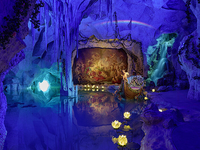 Blau illumnierte Grotte mit einem Boot mit Putten im Wasser und einem Wandfresko im Hintergrund